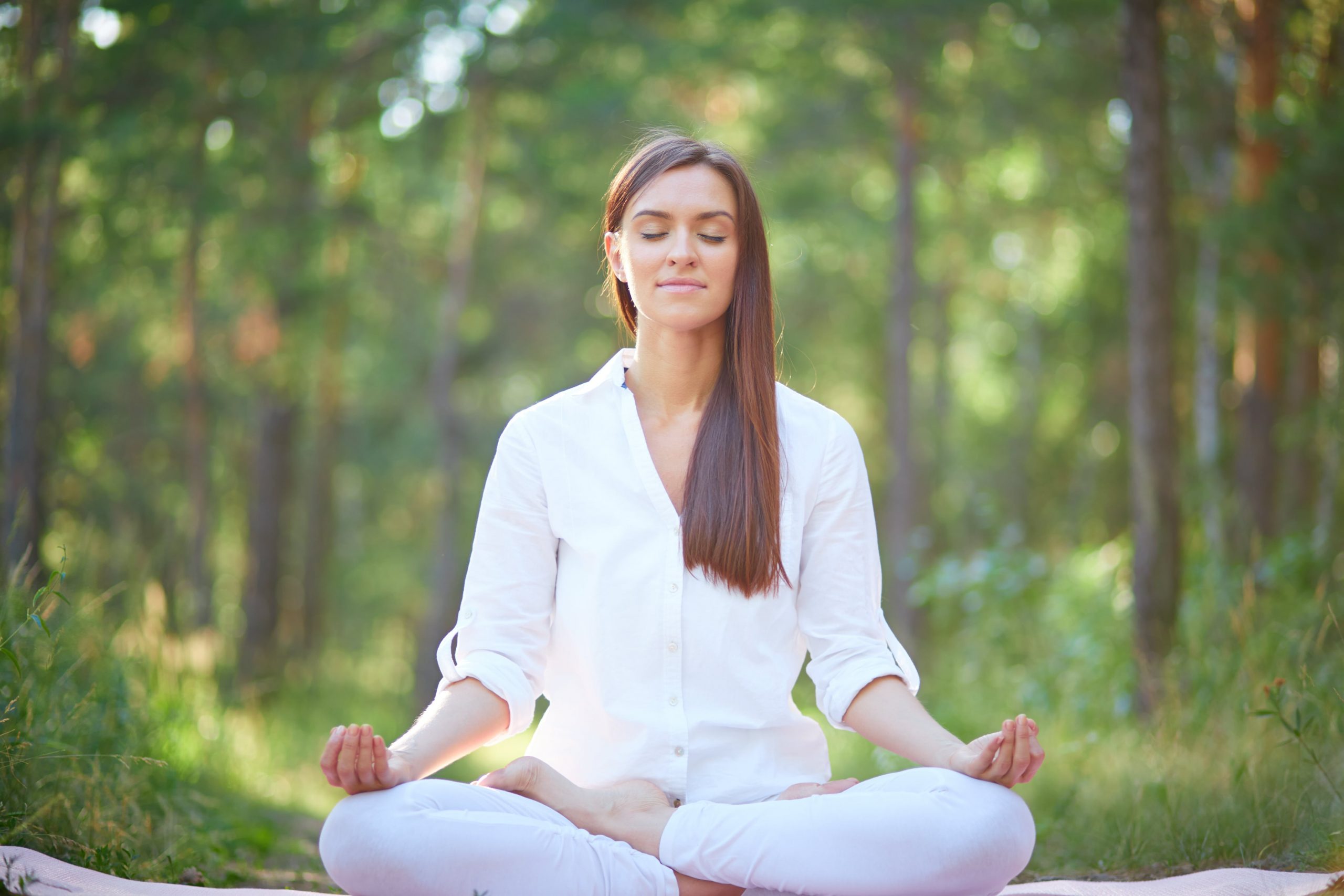 concentrated woman meditating nature min